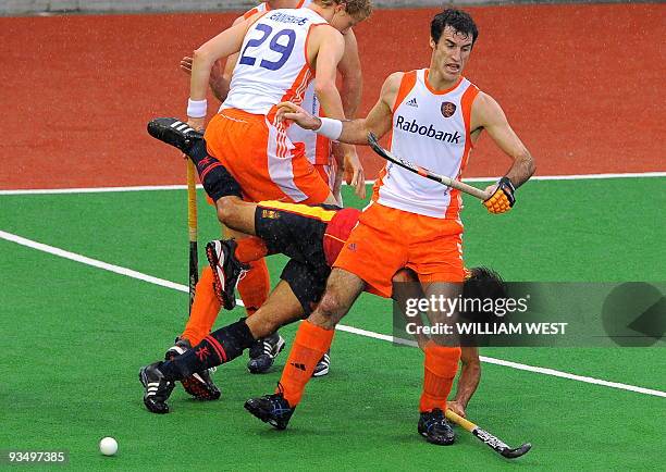 Marcel Balkestein and Tim Jenniskens of the Netherlands tackle Spain's Eduard Arbos during their Champions Trophy field hockey match played in...