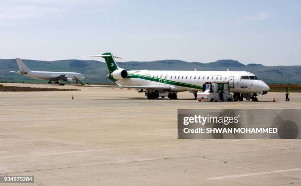 Picture taken on March 20, 2018 shows an Iraqi Airways Canadair CRJ-900 jet plane and another Airbus plane on the tarmac at the airport in the Iraqi...