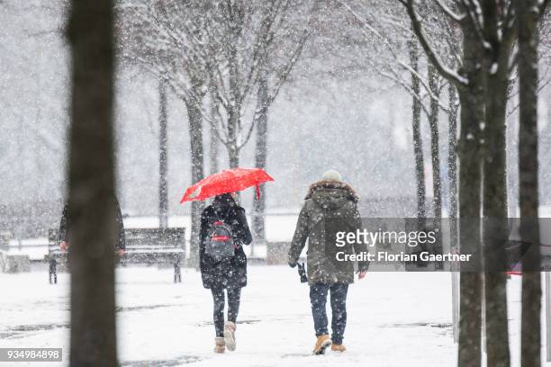 Two person walk during snow fall on March 20, 2018 in Berlin, Germany.