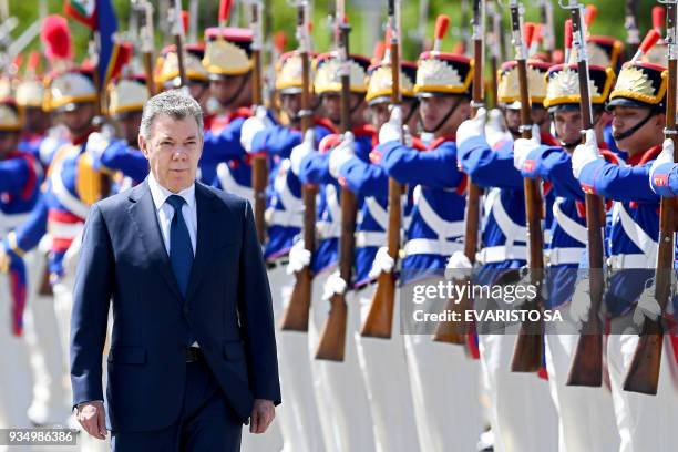 Colombia's President Juan Manuel Santos reviews the honour guard during his welcoming ceremony at Planalto Palace in Brasilia, where he will meet his...