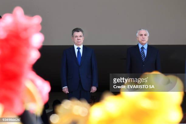 Colombia's President Juan Manuel Santos and Brazilian President Michel Temer listen to their national anthems during the former's welcoming ceremony...