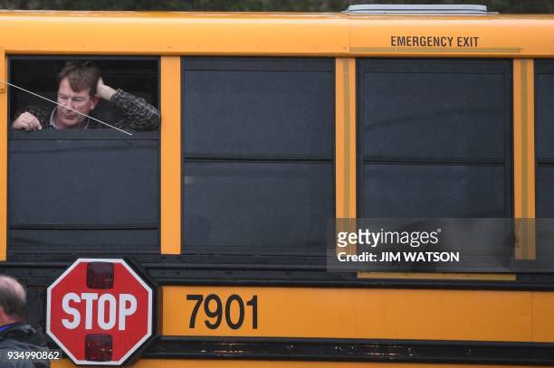 Man looks out of a school bus on March 20, 2018 at Great Mills High School in Great Mills, Maryland after a shooting at the school. A shooting took...