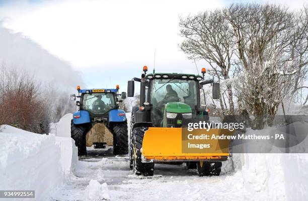 Farmers in their tractors help to clear the snow from a blocked road heading out of Simonsbath in Exmoor National park, as the icy conditions brought...