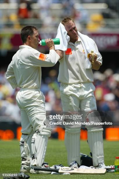 Australian opening batsmen Justin Langer and Matthew Hayden take a break during the first day of the 1st Test match against England at the Gabba in...
