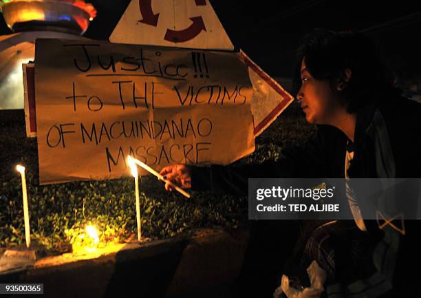 Resident lights a candle during an indignation rally in the town of Koronadal, south Cotabato province on November 25 as investigators in Ampatuan...