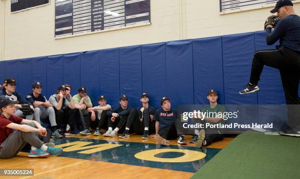 Yarmouth High School baseball team watches their head coach Marc Halsted demonstrate a pitch during the first day of baseball practice.