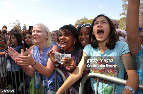 Fans watch Miley Cyrus perform at the A Time for Heroes Celebrity Carnival Sponsored by Disney, benefiting the Elizabeth Glaser Pediatric AIDS...