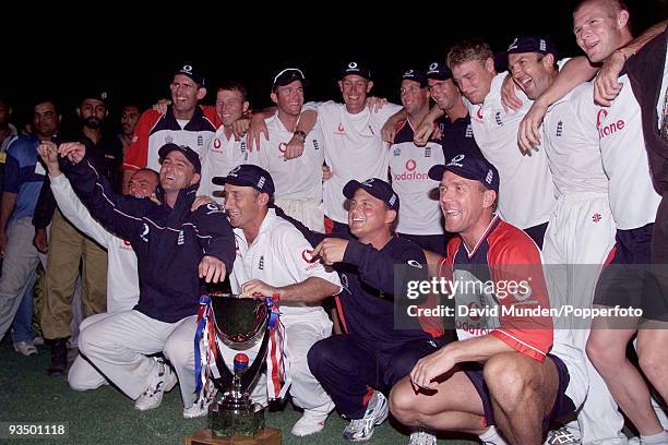 Delighted England captain Nasser Hussain and his team celebrate with the trophy after clinching a dramatic victory in near darkness at the end of the...