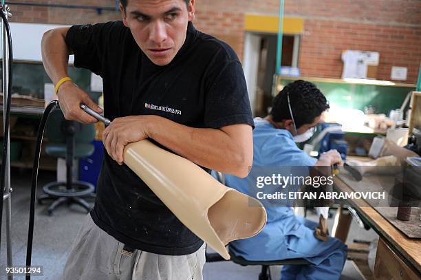 Jose Bernarno Calderon, a victim of a landmine explosion, works on a prosthesis at the Colombian Centre for Integrated Rehabilitacion in Bogota on...