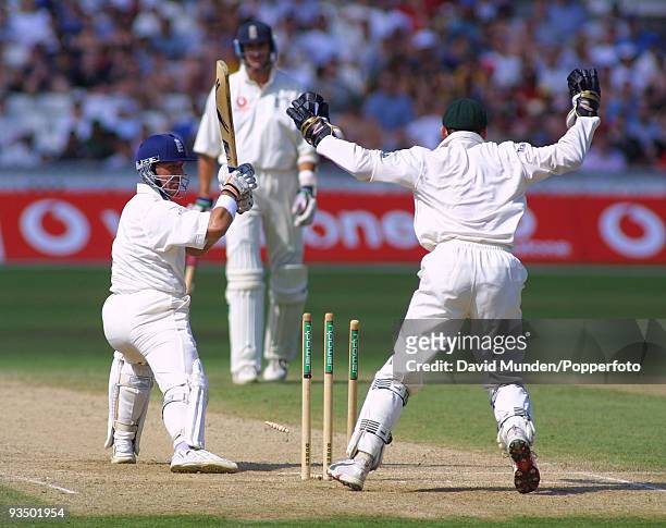 Australian wicketkeeper Adam Gilchrist celebrates as England batsman Alec Stewart leaves the ball and is bowled by Shane Warne for 34 runs during...