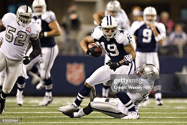 Wide receiver Miles Austin of the Dallas Cowboys is tackled by defensive back Chris Johnson of the Oakland Raiders at Cowboys Stadium on November 26,...