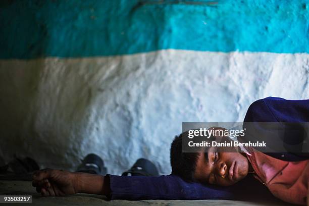 Fifteen year old Sachin Kumar rests in his home in a slum near the site of the deserted Union Carbide factory on November 30, 2009 in Bhopal, India....