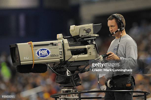 Fox Sports cameraman runs a TV camera during the game between the Detroit Lions and the Green Bay Packers at Ford Field on November 26, 2009 in...