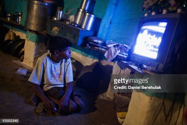 Fifteen year old Sachin Kumar watches television in his home located in a slum near the site of the deserted Union Carbide factory on November 30,...
