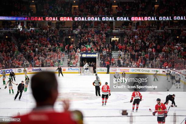 General view of the United Center as the ice crew helps to pick hats thrown by fans after Chicago Blackhawks right wing Alex DeBrincat scored a...