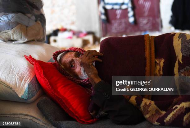 Khalil Tamr, 82-years-old, who fled the city of Afrin in northern Syria, lies inside an abandoned house in the village of az-Ziyarah, an area that is...