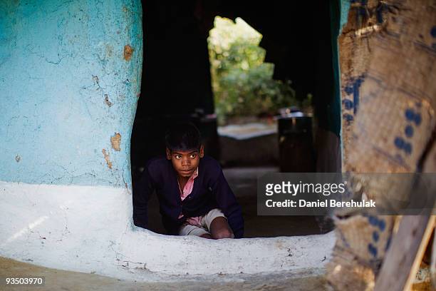 Year old Sachin Kumar peers out his family home in a slum near the site of the deserted Union Carbide factory on November 30, 2009 in Bhopal, India....