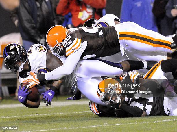 Running back Willis McGahee of the Baltimore Ravens is tackled by linebacker David Bowens and defensive back Brodney Pool of the Cleveland Browns...