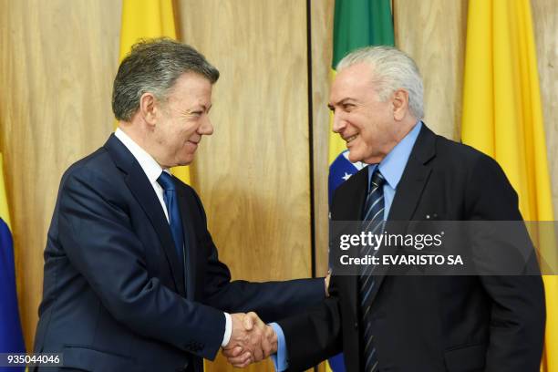 Colombia's President Juan Manuel Santos and Brazilian President Michel Temer shake hands after signing agreements during a ceremony at Planalto...