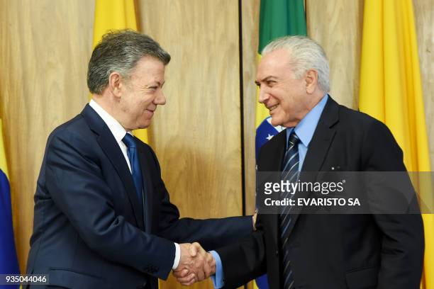Colombia's President Juan Manuel Santos and Brazilian President Michel Temer shake hands after signing agreements during a ceremony at Planalto...