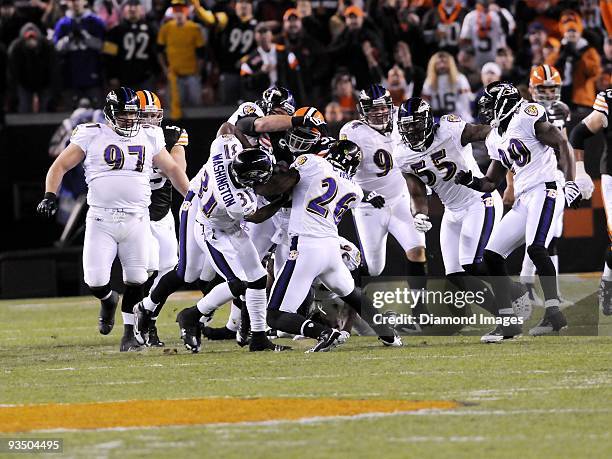 Running back Jamal Lewis of the Cleveland Browns is gang-tackled by defensive backs Fabian Washington and Dawan Landry as defensive linemen Kelly...