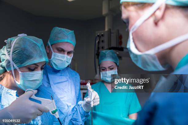 doctors performing surgery in operating theater - laparoscopic surgery stock pictures, royalty-free photos & images