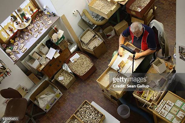 An artisan prepares miniature, wooden parts for Christmas figurines at the Richard Glaesser GmbH wooden toy manufactory on November 30, 2009 in...