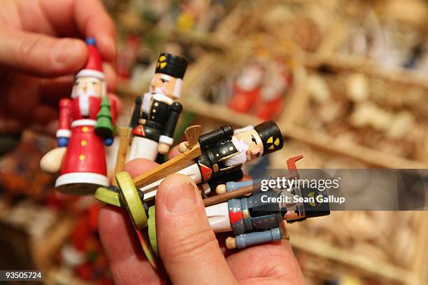 Visitor chooses among hand-made, wooden Christmas figurines on display in one of the many shops specializing in wooden Christmas decorations on...