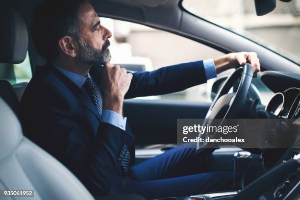 senior businessman driving his car - chauffeur stock pictures, royalty-free photos & images