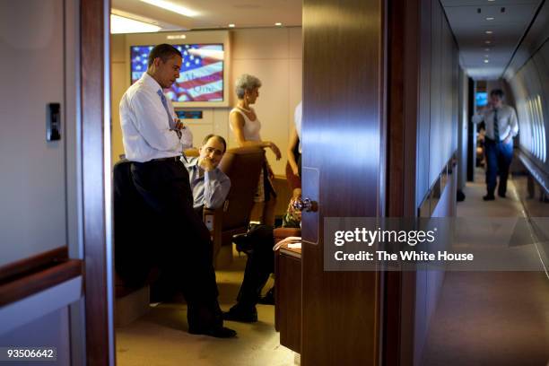 In this handout provided by the White House, President Barack Obama confers with aides aboard Air Force One November 14, 2009 en route to Singapore....