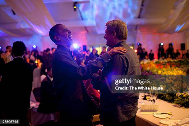 In this handout provided by the White House, President Barack Obama shares a laugh with Canadian Prime Minister Stephen Harper at the APEC leaders...