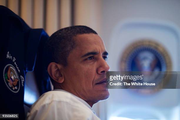 In this handout provided by the White House, President Barack Obama listens during a meeting with aides on Air Force One November 16, 2009 en route...