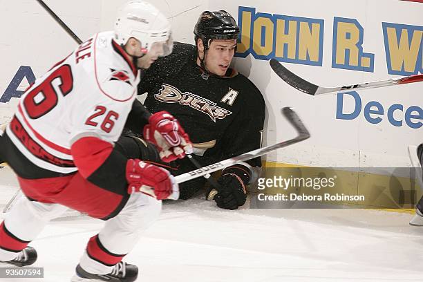 Erik Cole of the Carolina Hurricanes sends Ryan Getzlaf of the Anaheim Ducks into the boards during the game on November 25, 2009 at Honda Center in...
