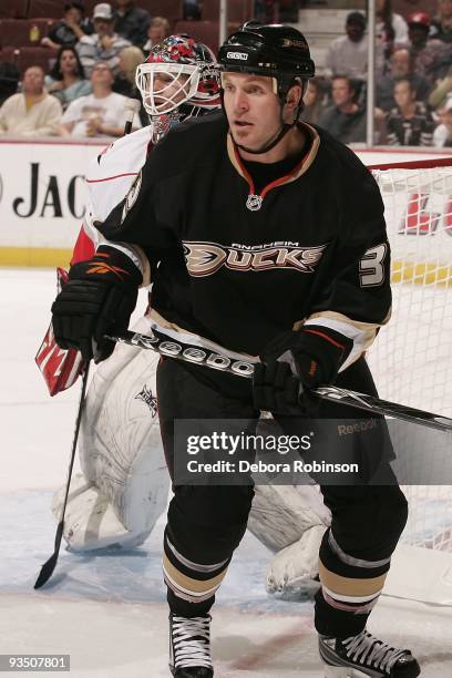 Jussi Jokinen of the Carolina Hurricanes and Corey Perry of the Anaheim Ducks defend outside the Hurricanes net during the game on November 25, 2009...