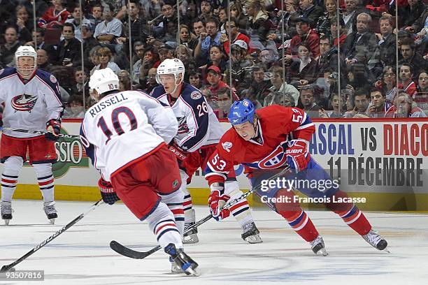 Kris Russell of the Columbus Blue Jackets handles the puck in front of Ryan White of the Montreal Canadiens on November 24, 2009 at the Bell Centre...