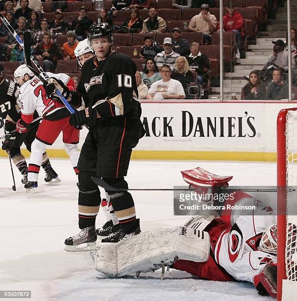Manny Legace of the Carolina Hurricanes falls into the crease defending the net against Corey Perry of the Anaheim Ducks during the game on November...