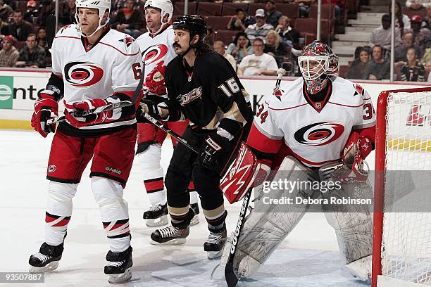 Tim Gleason and Manny Legace of the Carolina Hurricanes defend the net against George Parros of the Anaheim Ducks during the game on November 25,...