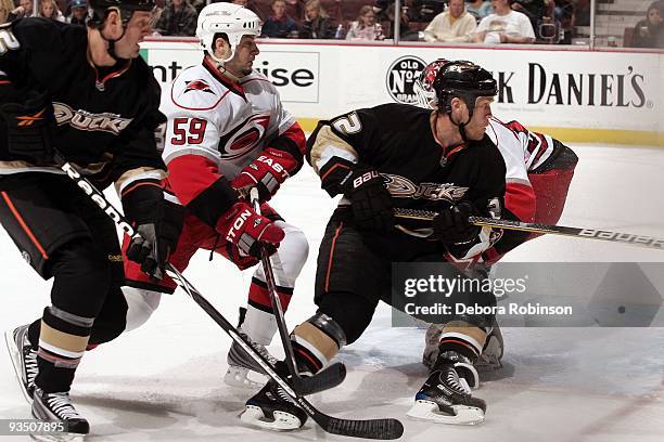 Chad LaRose of the Carolina Hurricanes defends against Kyle Calder and Todd Marchant of the Anaheim Ducks during the game on November 25, 2009 at...