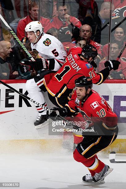 Fredrik Sjostrom and Brian McGrattan of the Calgary Flames skate against Brent Sopel of the Chicago Blackhawks on November 19, 2009 at Pengrowth...