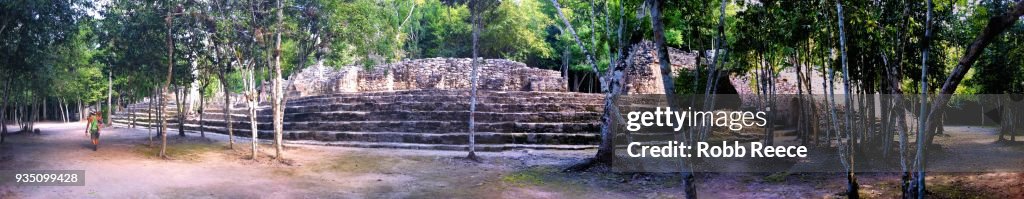 Woman walking near aztec ruins in jungle