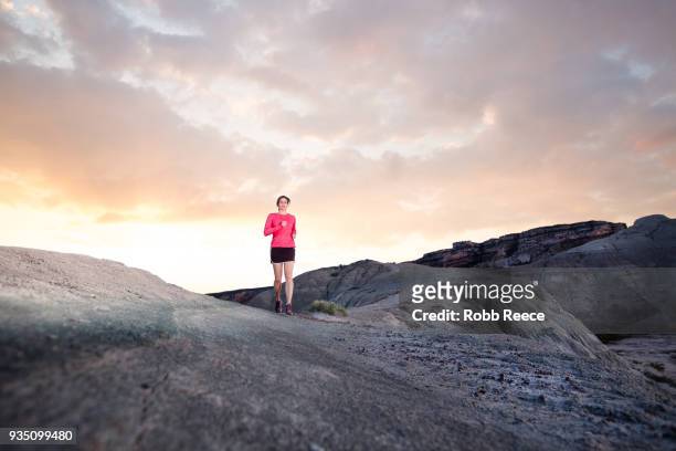 an adult woman trail running on a remote dirt trail - robb reece stock-fotos und bilder