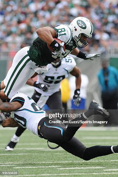 Dustin Keller of the New York Jets caries the ball and is upended during a NFL game against the Jacksonville Jaguars at Giants Stadium on November...