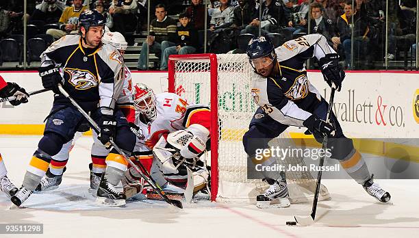 David Legwand and Joel Ward of the Nashville Predators skate in front of goalie Mikka Kiprusoff of the Calgary Flames on November 30, 2009 at the...