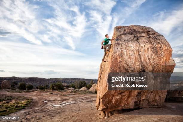 an adult man rock climbing on a rock in the desert - robb reece stock-fotos und bilder