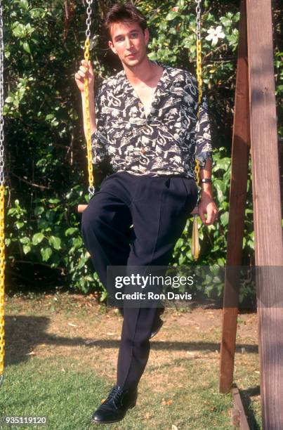 American film and television actor Noah Wyle sits on a swingset circa 1998 in Los Angeles, California.