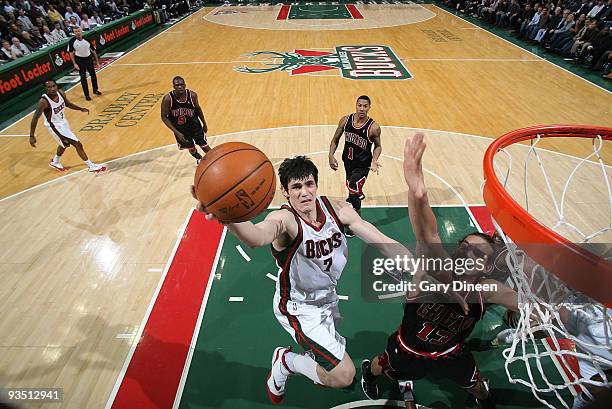 Ersan Ilyasova of the Milwaukee Bucks shoots a layup against Joakim Noah of the Chicago Bulls on November 30, 2009 at the Bradley Center in...