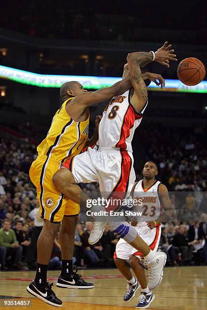 Monta Ellis of the Golden State Warriors is fouled by Earl Watson of the Indiana Pacers at Oracle Arena on November 30, 2009 in Oakland, California....