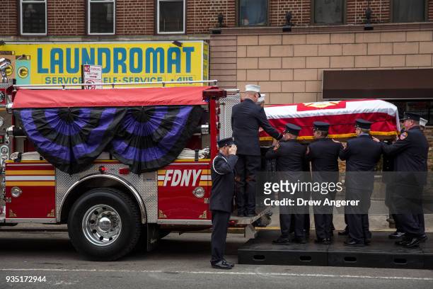 Members of the New York City fire department load the casket of firefighter Thomas Phelan onto a fire truck for a funeral service at St. Michael's...