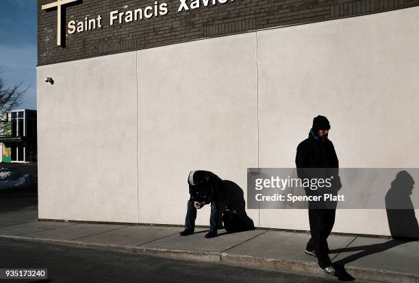 Men wait outside of a soup kitchen in an economically stressed section of the city on March 20, 2018 in Worcester, Massachusetts. Worcester, once a...