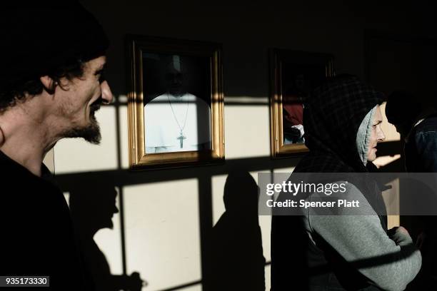 People walk into a soup kitchen and food pantry run by the Catholic church in an economically stressed section of the city on March 20, 2018 in...